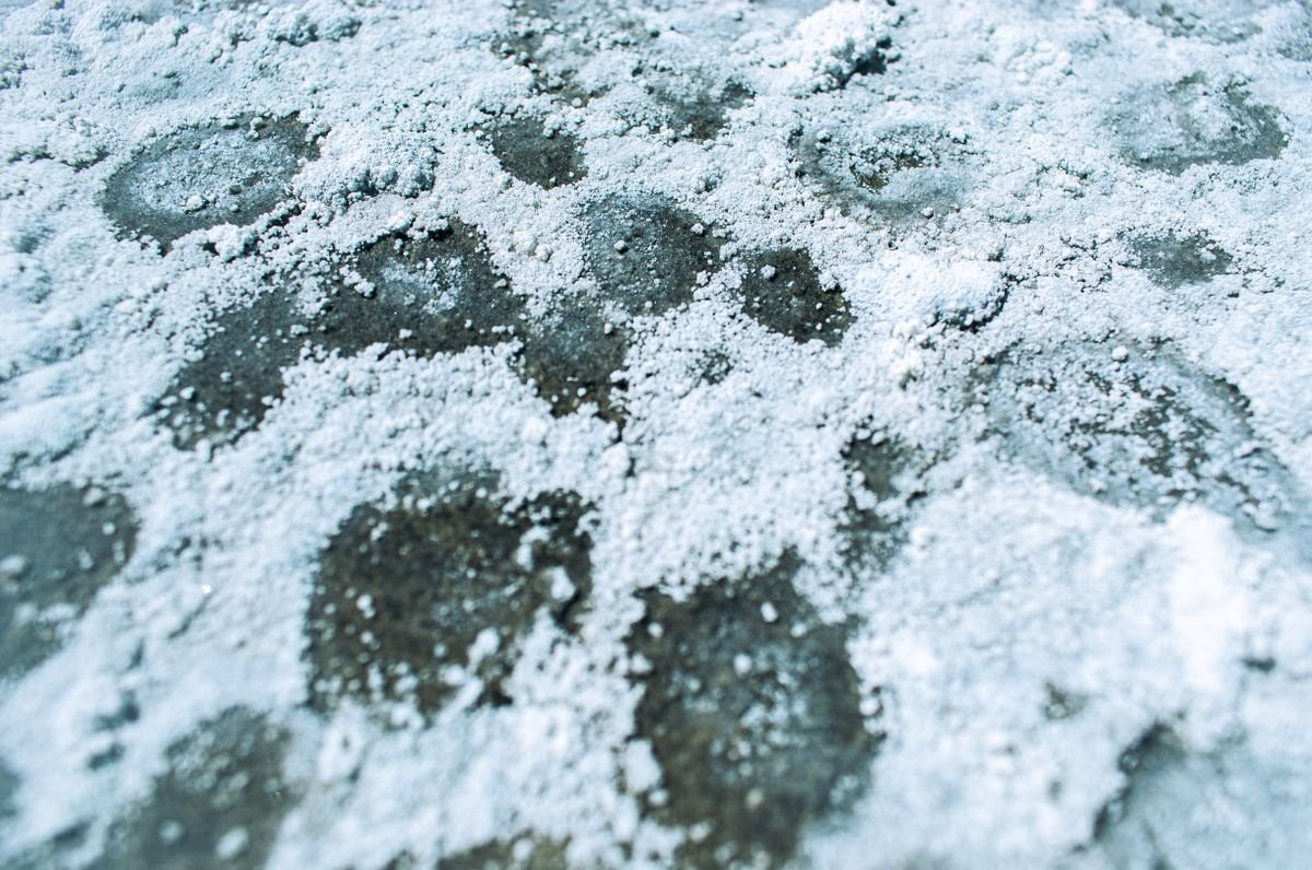 White crystalline salt deposits on a textured surface — analogue for the substrate crust that confirms peperomia fertilizer burn