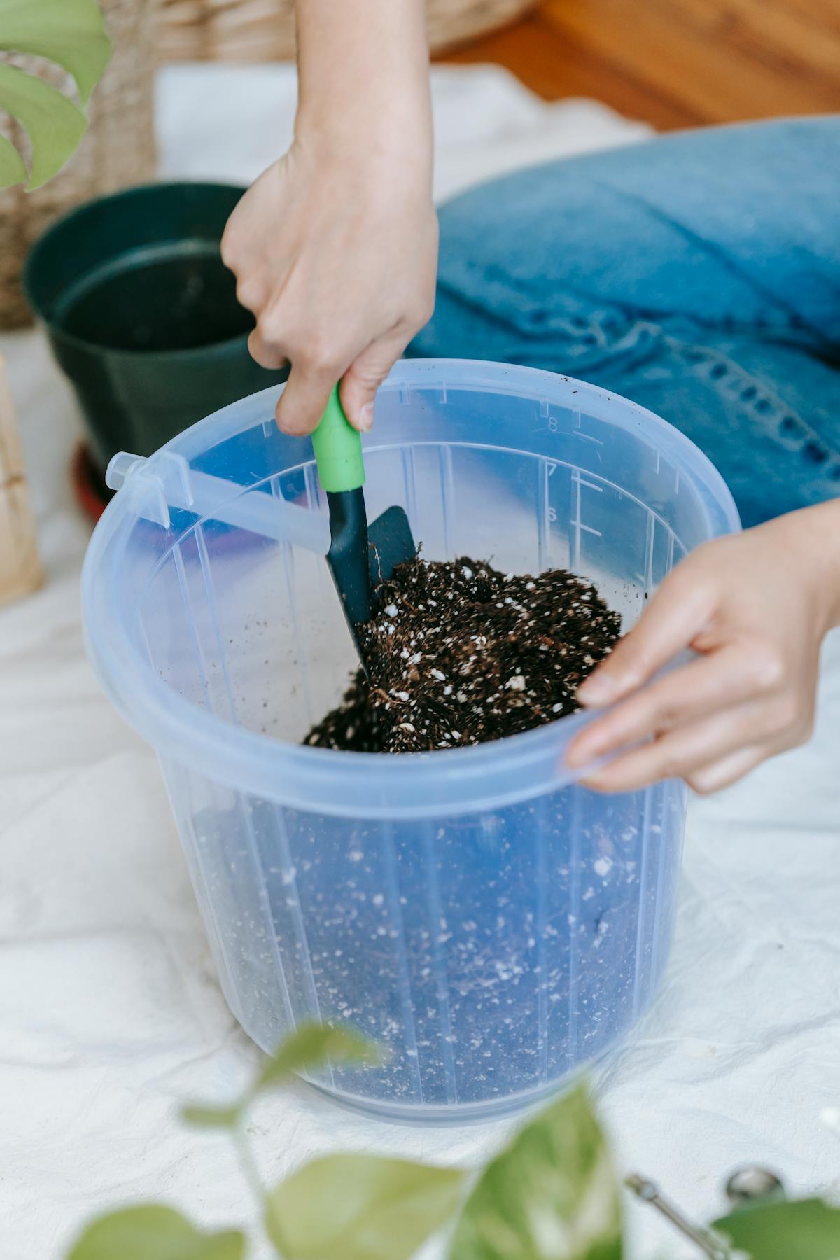 Crop anonymous female horticulturist loosening soil in house