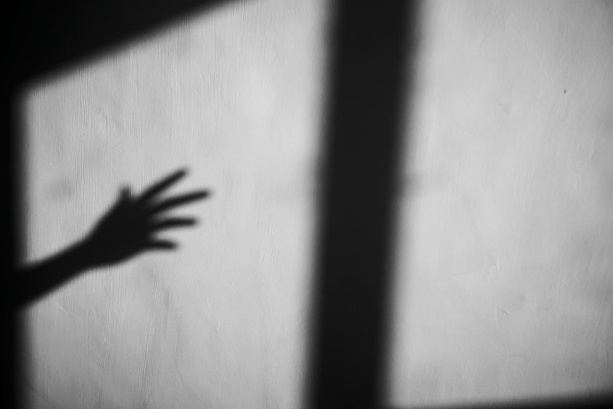 Shadow cast by an open hand against a window frame, illustrating a practical light-intensity field test